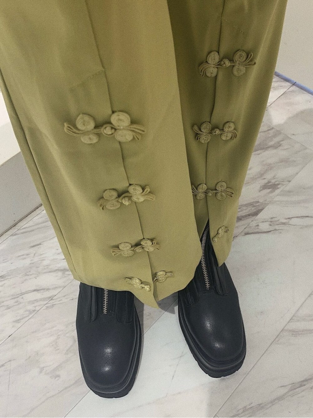 ブラック系のブーツ、ブラック系のブルゾン、グリーン系のその他パンツを着用したレディースの春コーディネートの7枚目の写真