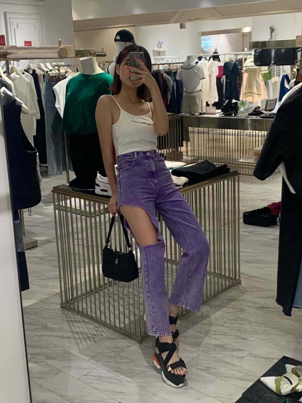 ホワイト系のキャミソール、パープル系のデニムパンツ、ブラック系のサンダルを着用したレディースの夏コーディネートの2枚目の写真