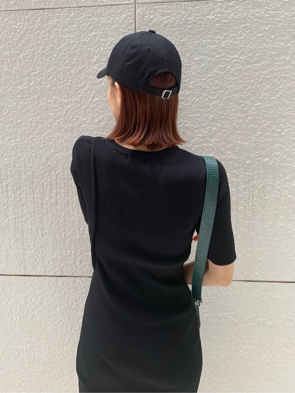 ブラック系のワンピース、ブラック系のブーツ、グリーン系のショルダーバッグを着用したレディースの夏コーディネートの4枚目の写真