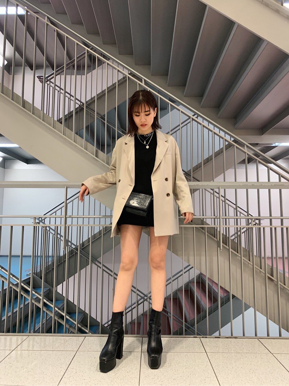 グレー系のテーラードジャケット、ブラック系のTシャツ/カットソー、ブラック系のスカートを着用したレディースの冬コーディネートの2枚目の写真