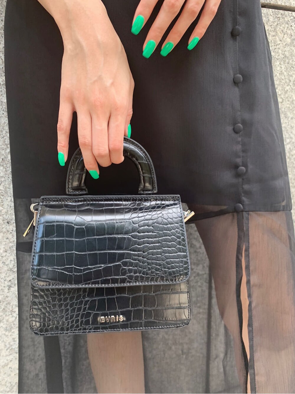 ブラック系のスカート、ブラック系のTシャツ/カットソー、ブラック系のサンダルを着用したレディースの夏コーディネートの9枚目の写真