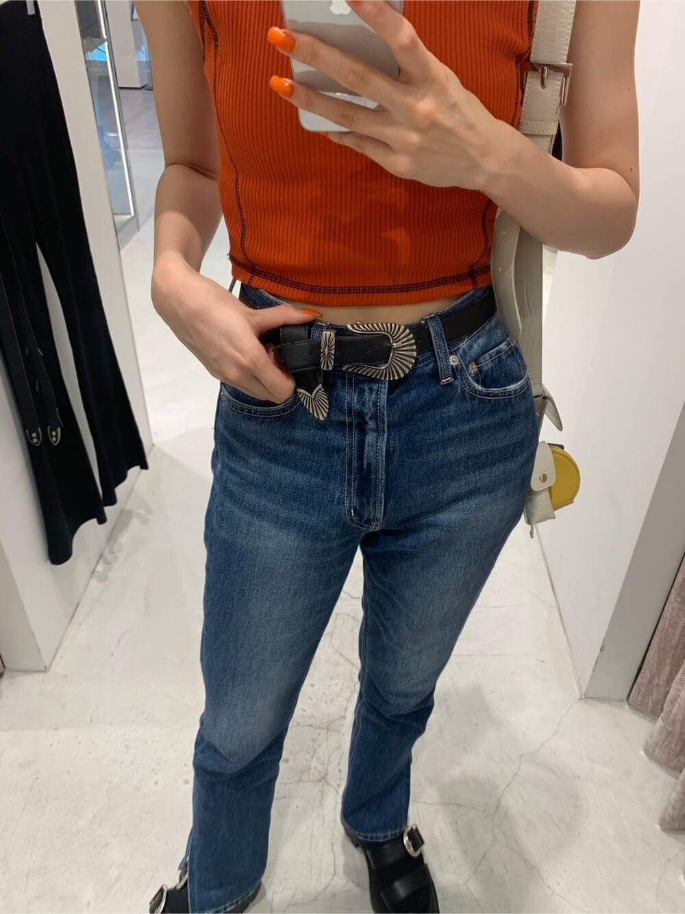 ホワイト系のショルダーバッグ、オレンジ系のTシャツ/カットソー、ブラック系のサンダルを着用したレディースの夏コーディネートの5枚目の写真