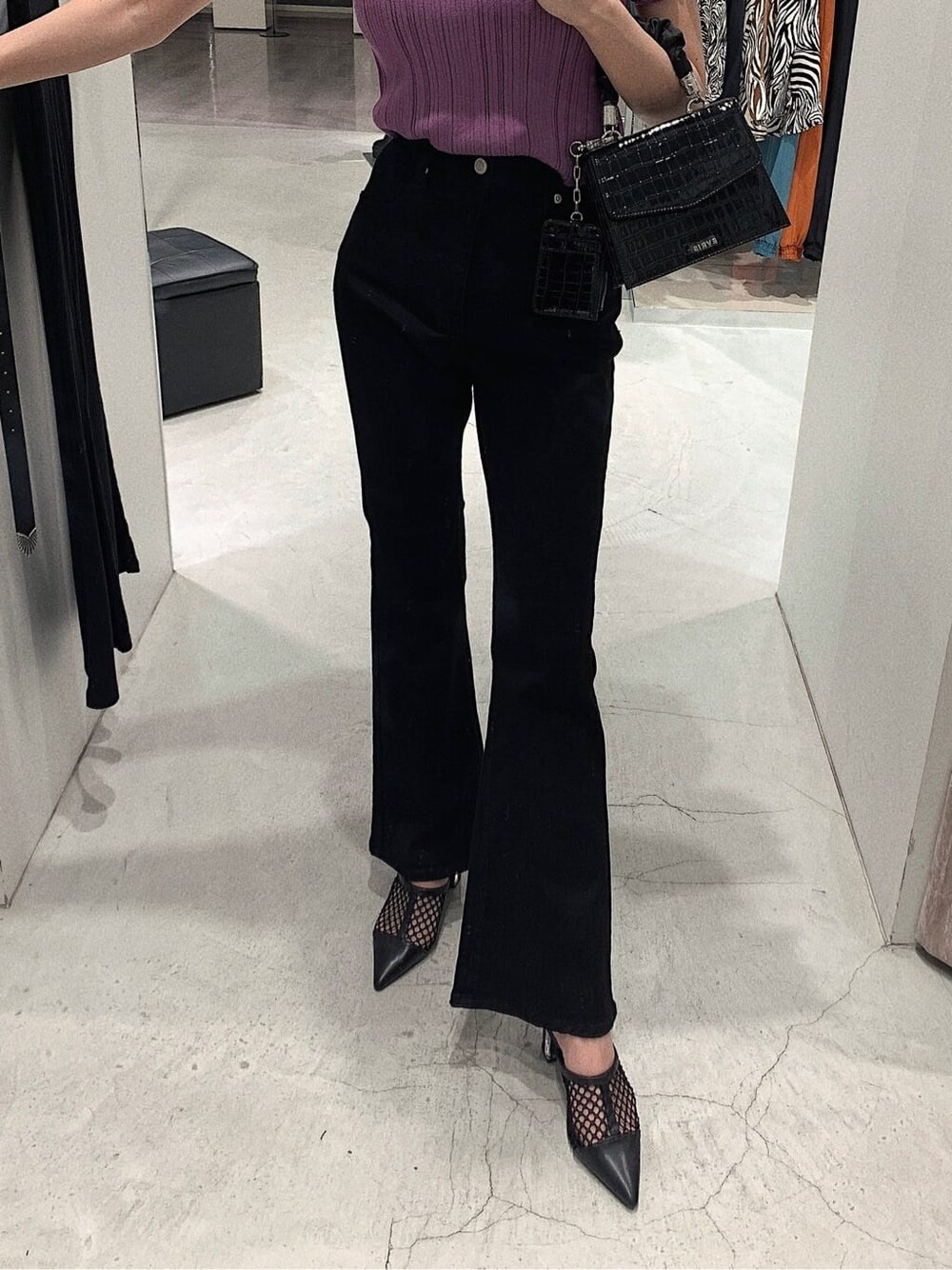 ブラック系のパンプス、ブラック系のデニムパンツ、パープル系のニット/セーターを着用したレディースの春コーディネートの4枚目の写真