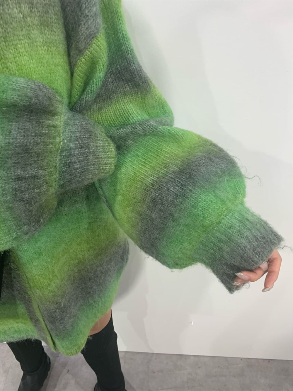 グリーン系のカーディガン/ボレロ、ブラック系のブーツ、ブラック系のショルダーバッグを着用したレディースの秋コーディネートの6枚目の写真