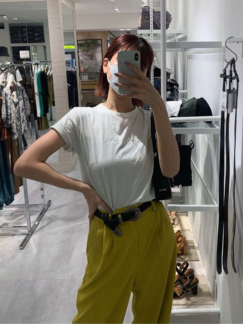 イエロー系のスラックス、ホワイト系のTシャツ/カットソー、ブラック系のブーツを着用したレディースの春コーディネートの2枚目の写真