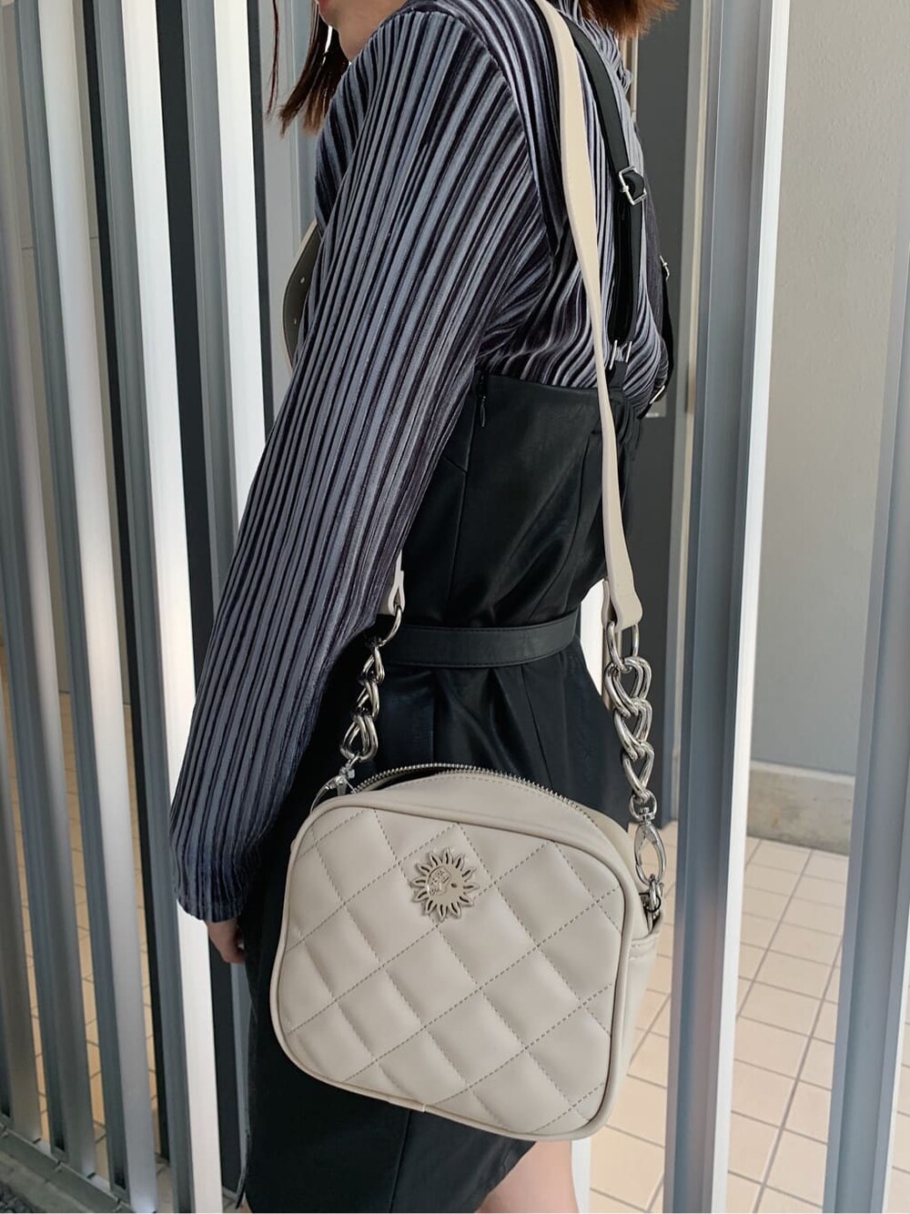 グレー系のTシャツ/カットソー、ブラック系のブーツ、ホワイト系のショルダーバッグを着用したレディースの秋コーディネートの6枚目の写真