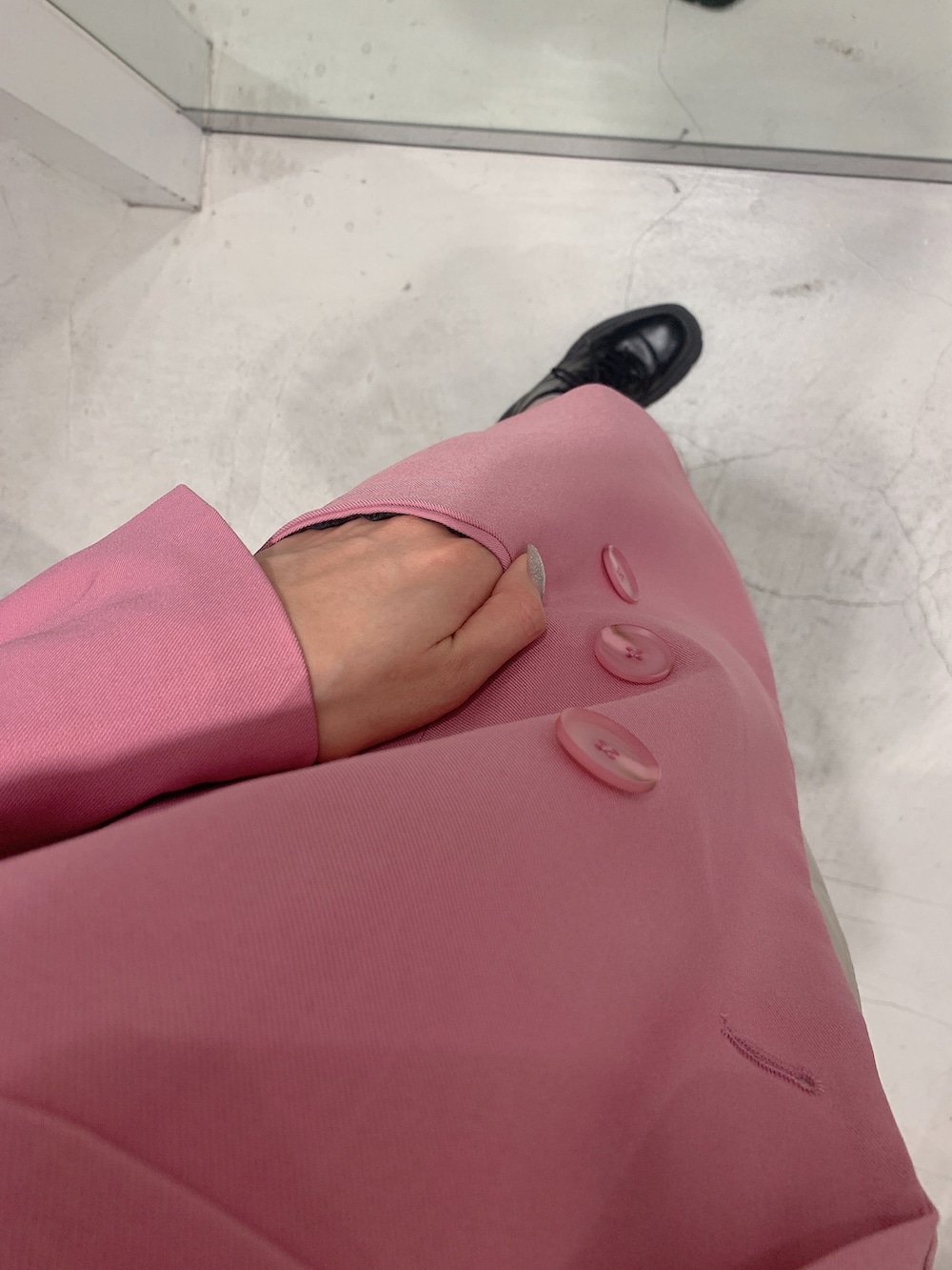 ピンク系のテーラードジャケット、ホワイト系のスカート、ブラック系のショルダーバッグを着用したレディースの冬コーディネートの5枚目の写真