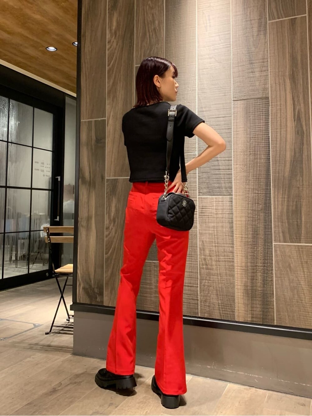 レッド系のその他パンツ、ブラック系のショルダーバッグ、ブラック系のブーツを着用したレディースの夏コーディネートの2枚目の写真