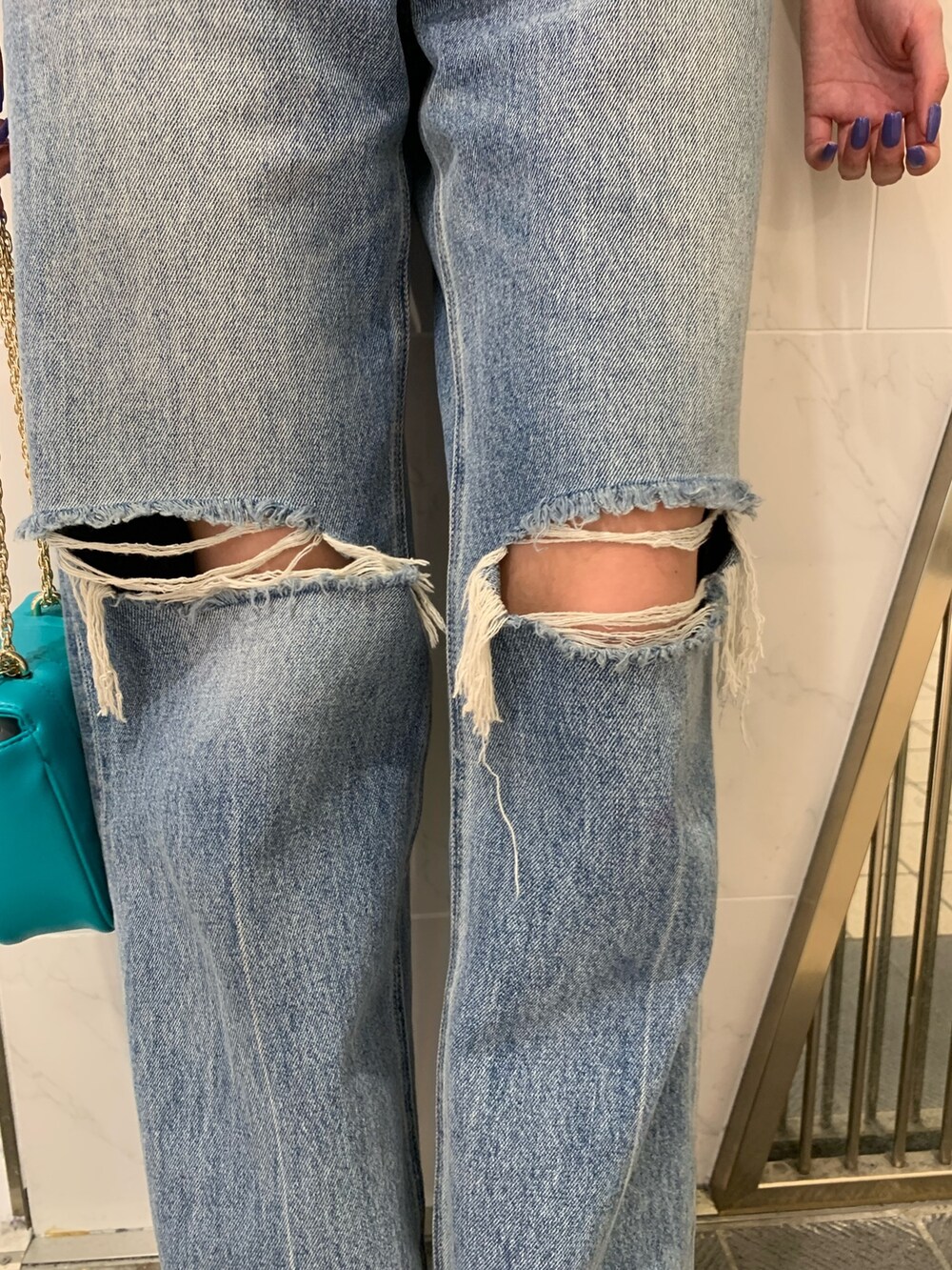 ブラック系のブーツ、ブルー系のデニムパンツ、ブルー系のショルダーバッグを着用したレディースの夏コーディネートの8枚目の写真