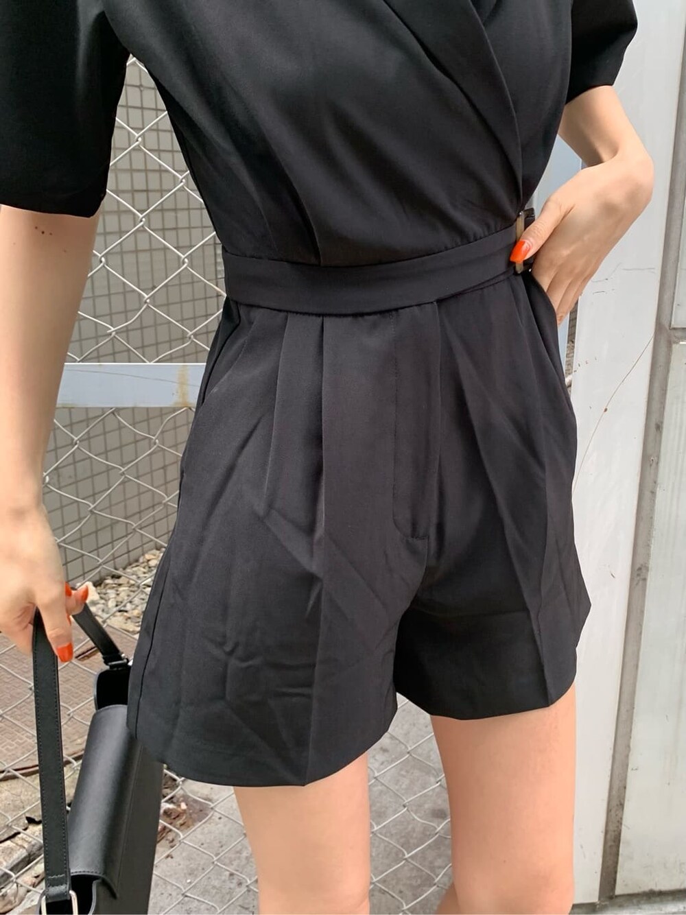 ブラック系のブーツ、ブラック系のつなぎ/オールインワン、ブラック系のショルダーバッグを着用したレディースの春コーディネートの6枚目の写真