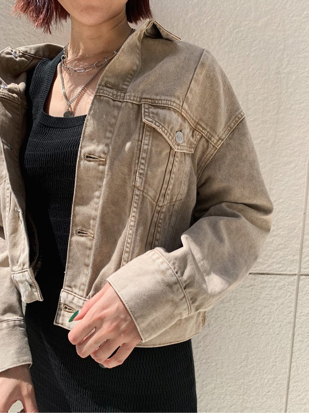 ベージュ系のデニムジャケット、ブラック系のブーツ、その他のショルダーバッグを着用したレディースの秋コーディネートの4枚目の写真