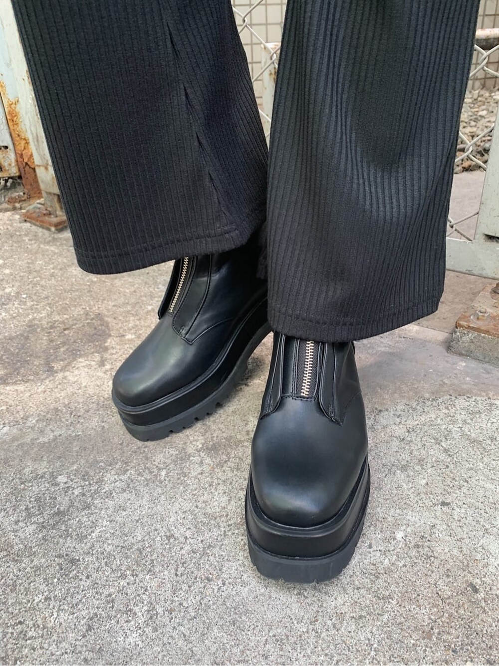 ブラック系のその他パンツ、ブラック系のブーツ、ブルー系のニット/セーターを着用したレディースの春コーディネートの9枚目の写真