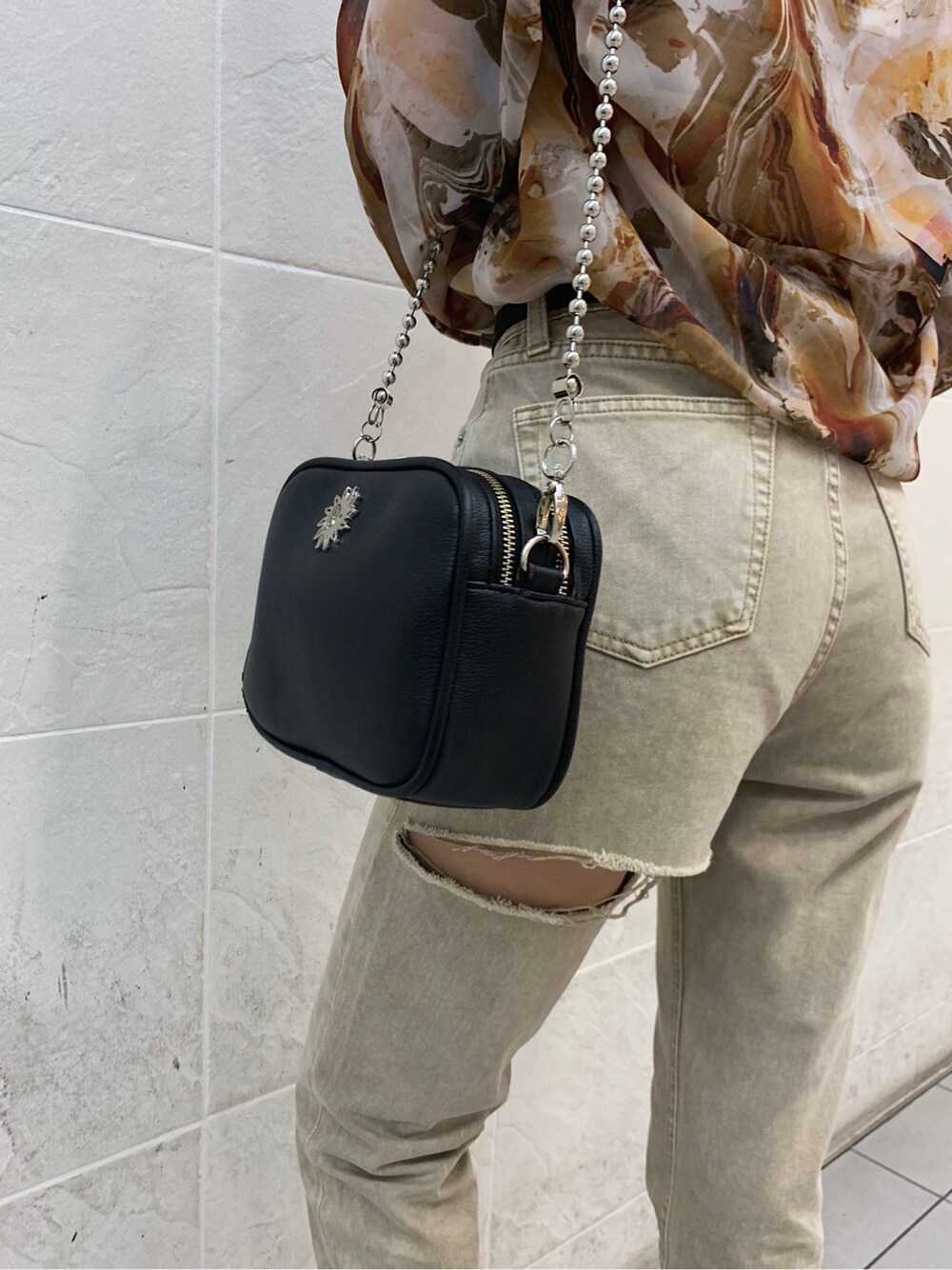 ブラウン系のキャミソール、ブラック系のサンダル、ベージュ系のデニムパンツを着用したレディースの春コーディネートの7枚目の写真