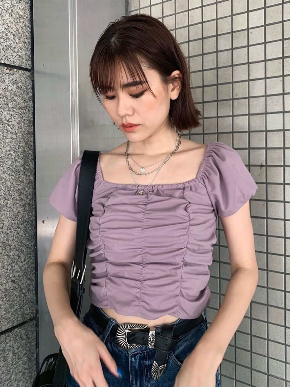 ブルー系のデニムパンツ、ブラック系のサンダル、ブラック系のベルトを着用したレディースの夏コーディネートの3枚目の写真