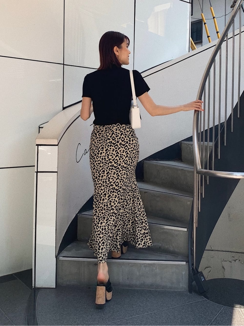 ブラック系のニット/セーター、ホワイト系のショルダーバッグ、その他のスカートを着用したレディースの春コーディネートの2枚目の写真