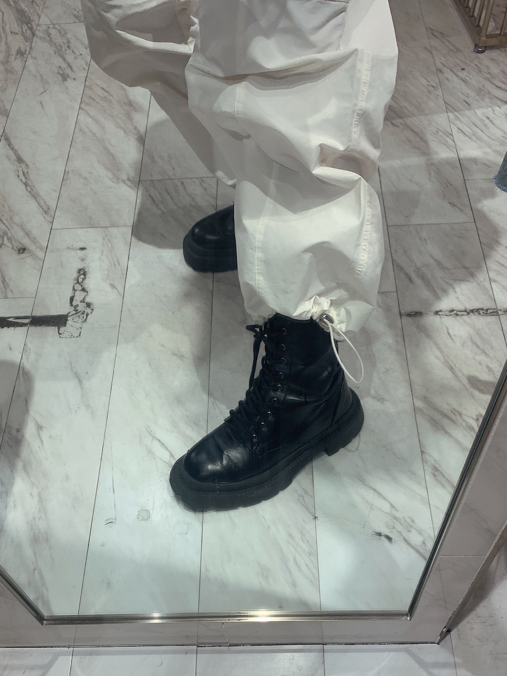ホワイト系のカーゴパンツ、ブラック系のニット/セーター、グリーン系のショルダーバッグを着用したレディースの春コーディネートの9枚目の写真