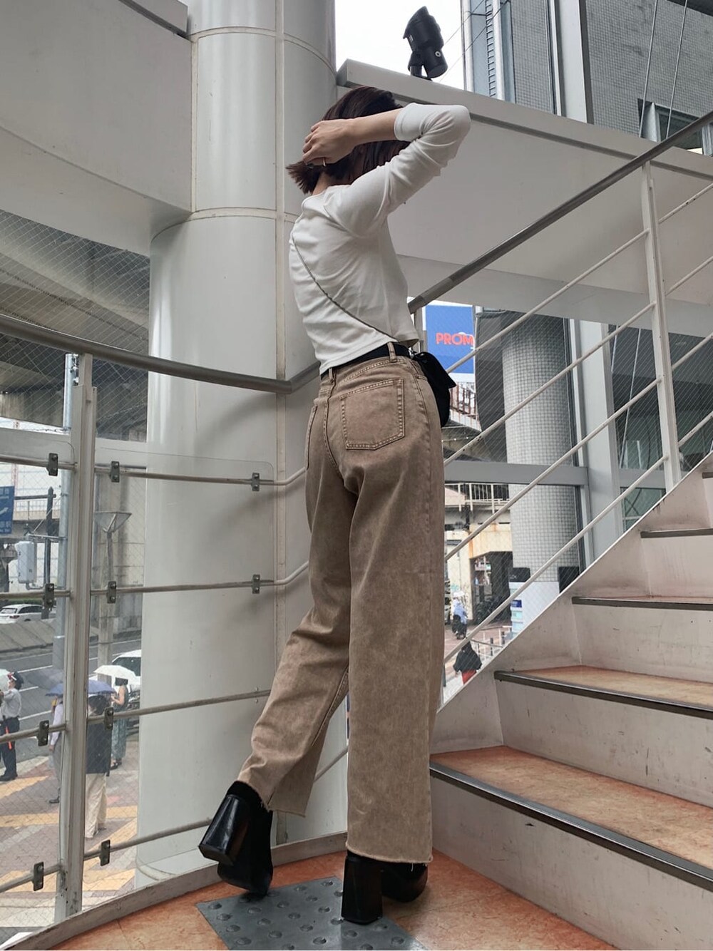 ホワイト系のTシャツ/カットソー、ベージュ系のデニムパンツ、ブラック系のベルトを着用したレディースの秋コーディネートの2枚目の写真