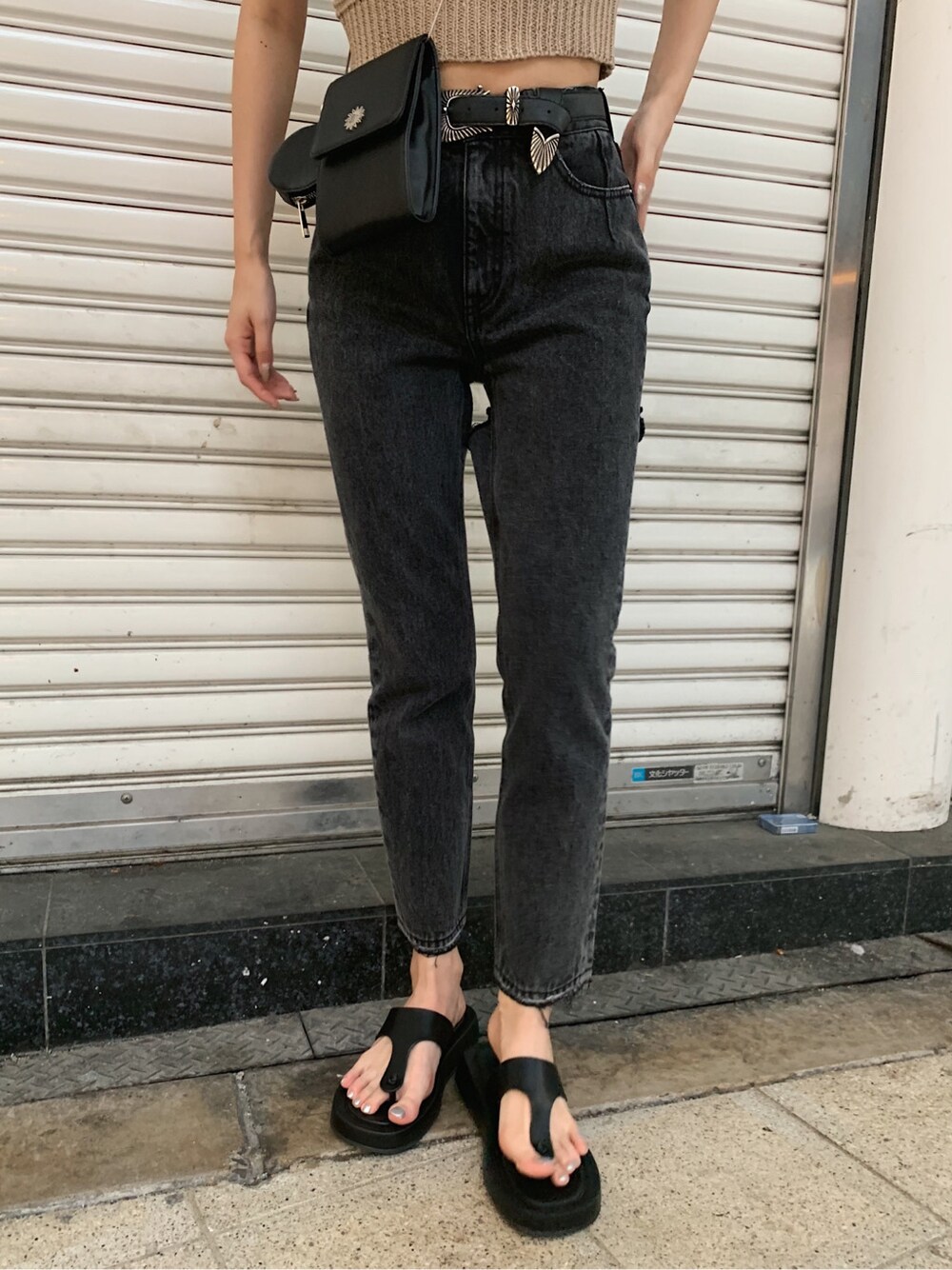 ブラック系のサンダル、ブラック系のデニムパンツ、ベージュ系のタンクトップを着用したレディースの春コーディネートの7枚目の写真