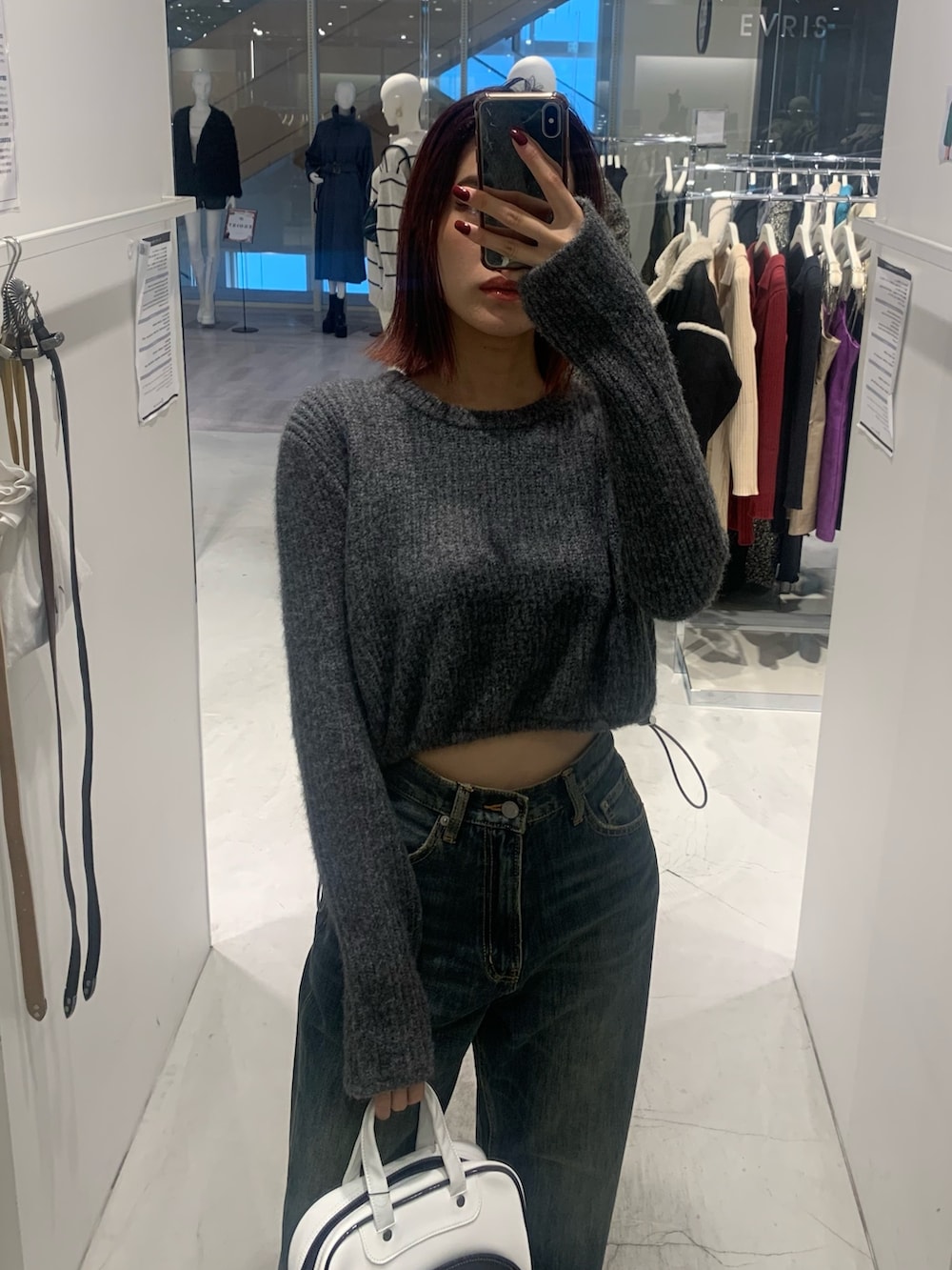 グレー系のニット/セーター、ブルー系のデニムパンツ、ブラック系のブーツを着用したレディースの秋コーディネートの3枚目の写真