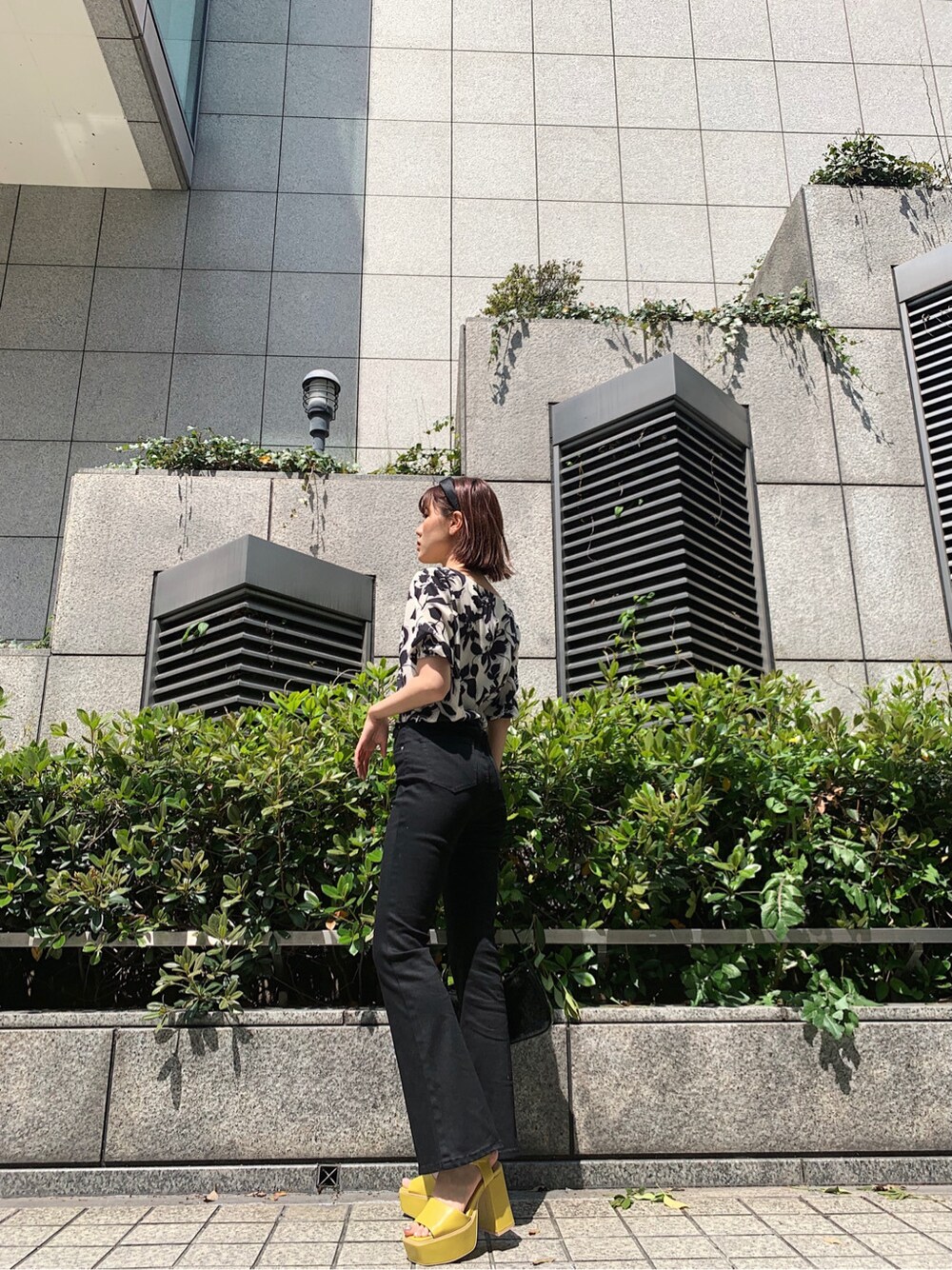 ホワイト系のシャツ/ブラウス、イエロー系のサンダル、ブラック系のショルダーバッグを着用したレディースの春コーディネートの3枚目の写真