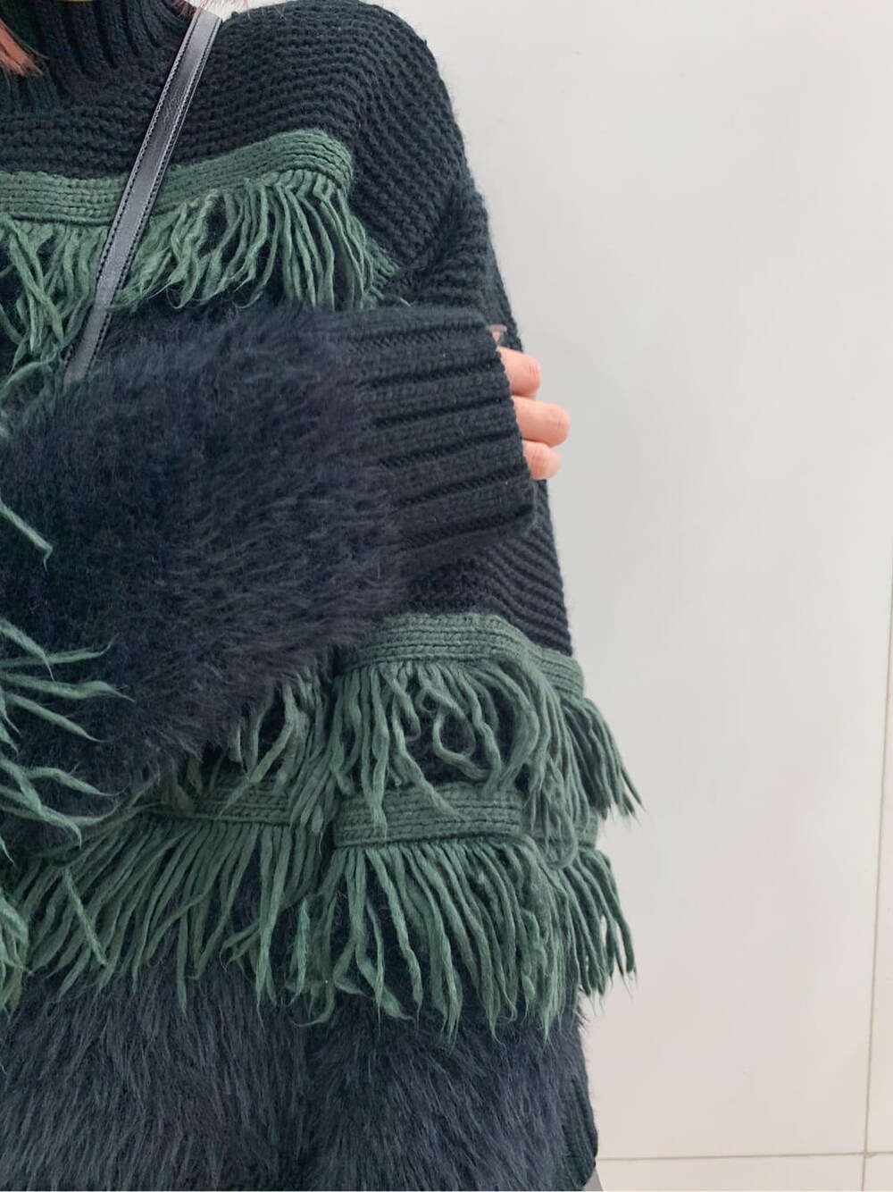 ブラック系のショルダーバッグ、ブラック系のブーツ、ブラック系のスカートを着用したレディースの冬コーディネートの4枚目の写真