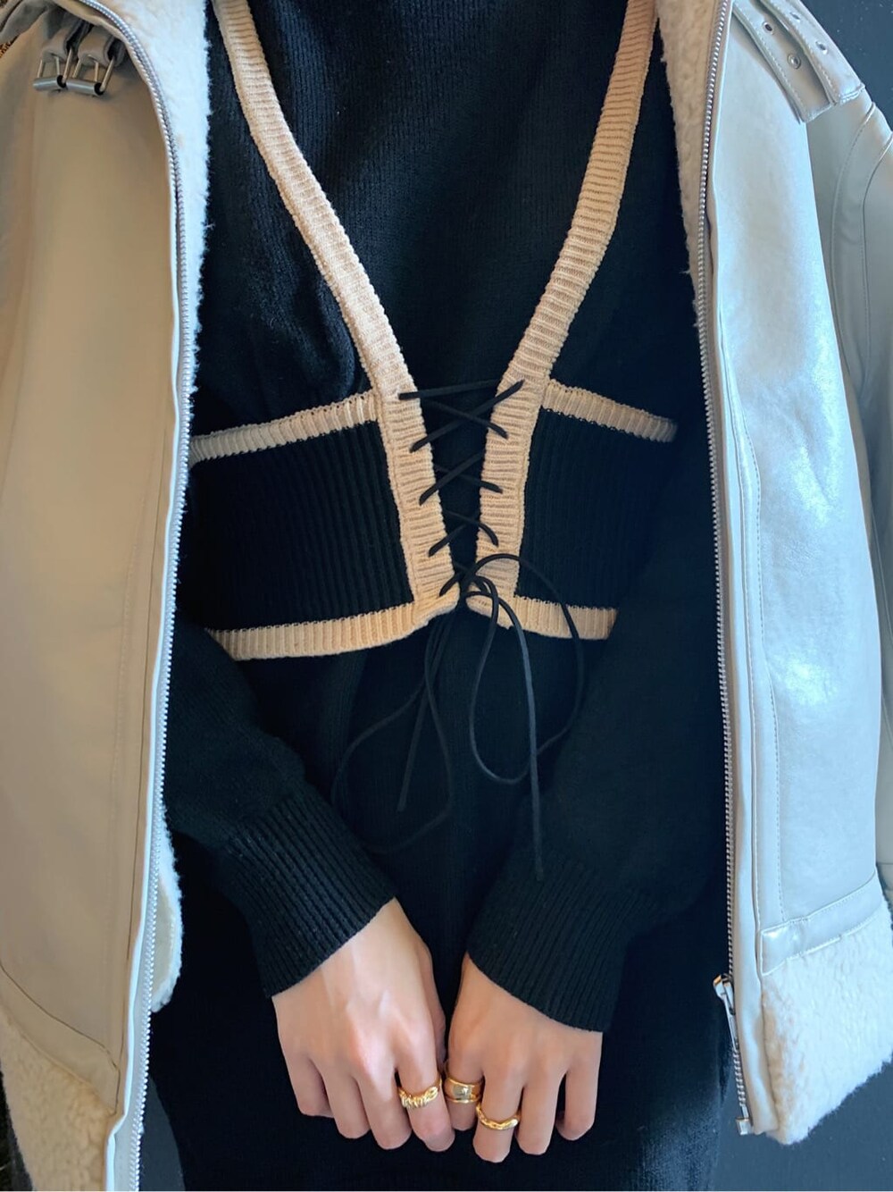 ホワイト系のブルゾン、ブラック系のブーツ、ゴールド系のリングを着用したレディースの冬コーディネートの5枚目の写真