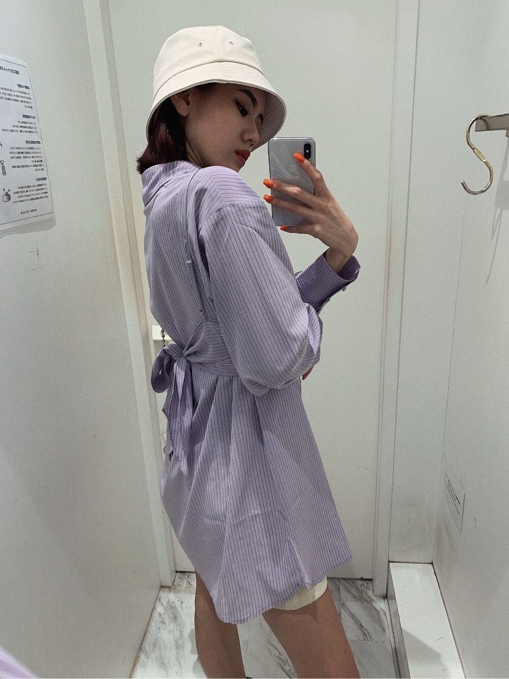 ホワイト系のスカート、ブラック系のブーツ、ホワイト系のショルダーバッグを着用したレディースの春コーディネートの3枚目の写真