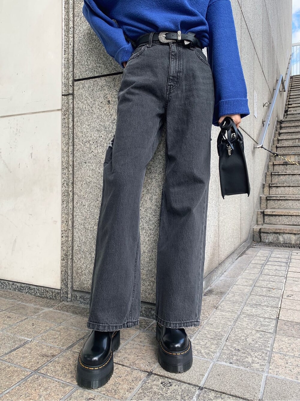 ブラック系のデニムパンツ、ブラック系のブーツ、ブラック系のショルダーバッグを着用したレディースの冬コーディネートの5枚目の写真