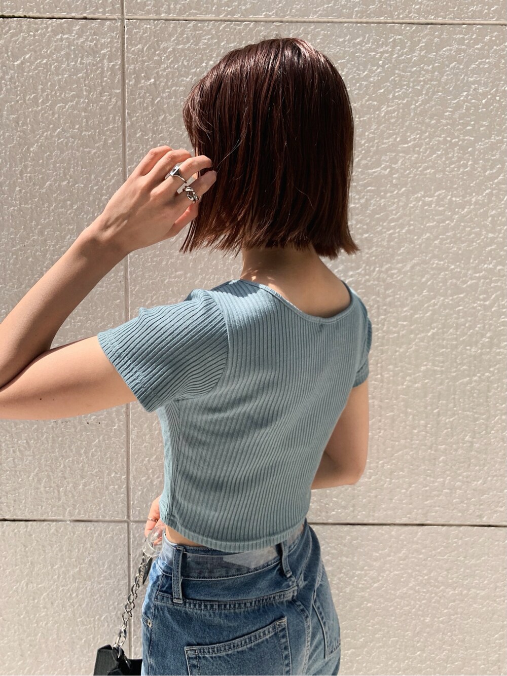 ブラック系のサンダル、ブルー系のデニムパンツ、その他のベルトを着用したレディースの春コーディネートの5枚目の写真