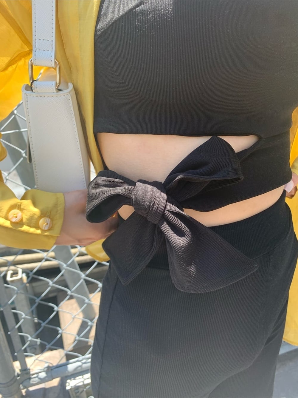 ブラック系のTシャツ/カットソー、ホワイト系のショルダーバッグ、ブラック系のその他パンツを着用したレディースの夏コーディネートの7枚目の写真