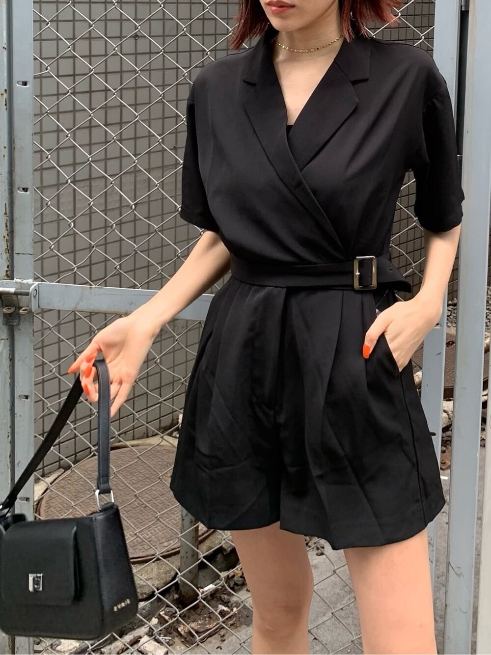 ブラック系のブーツ、ブラック系のつなぎ/オールインワン、ブラック系のショルダーバッグを着用したレディースの春コーディネートの4枚目の写真