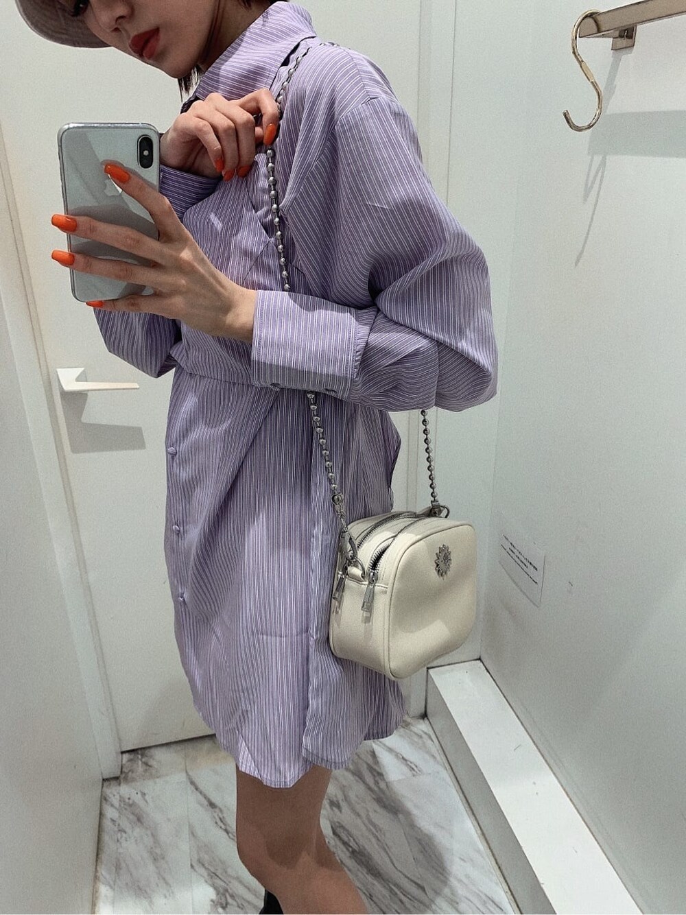 ホワイト系のスカート、ブラック系のブーツ、ホワイト系のショルダーバッグを着用したレディースの春コーディネートの7枚目の写真