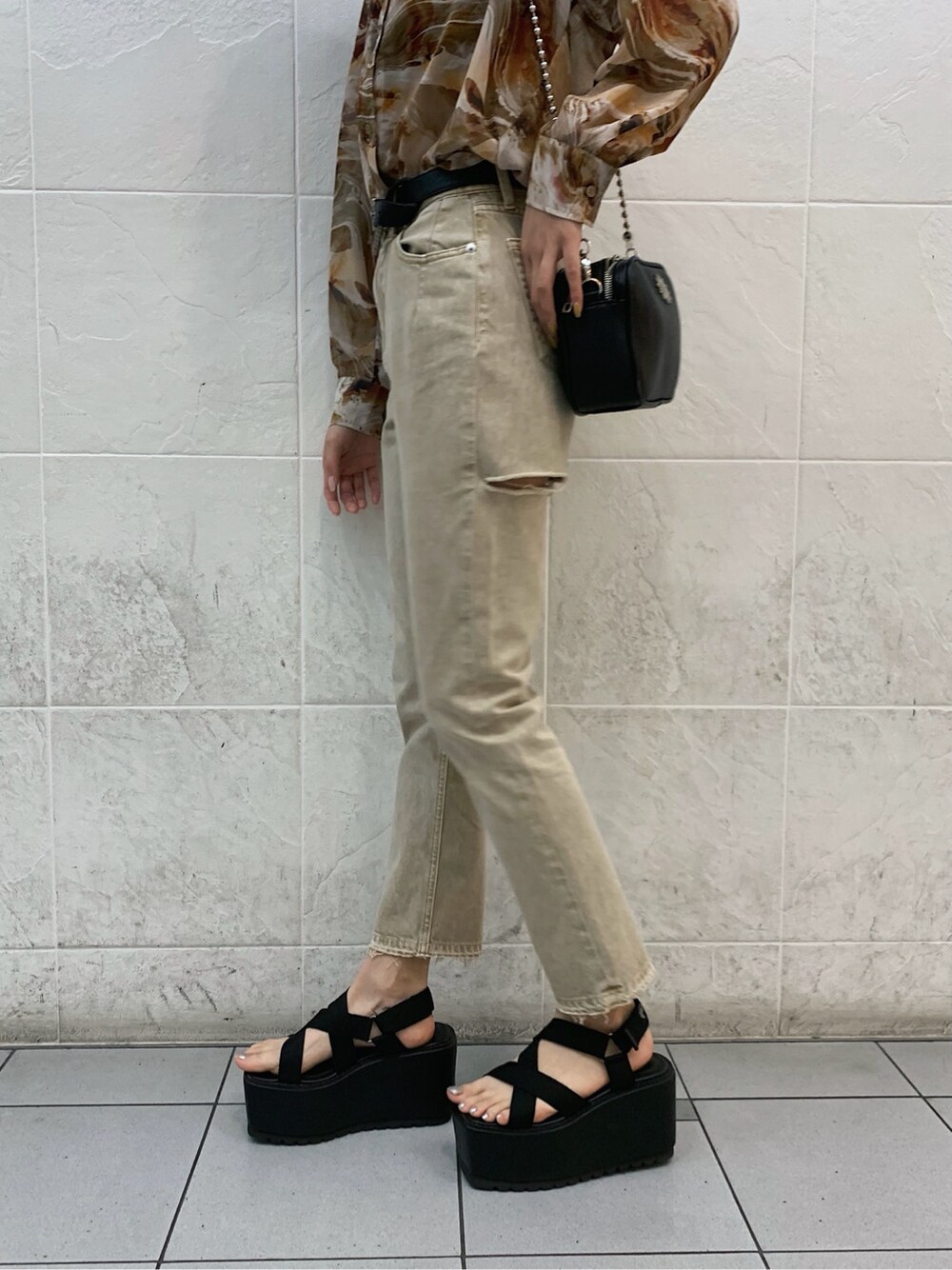 ブラウン系のキャミソール、ブラック系のサンダル、ベージュ系のデニムパンツを着用したレディースの春コーディネートの9枚目の写真