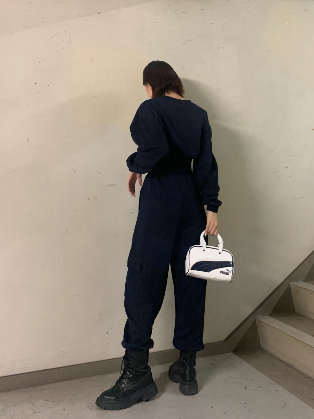 ブルー系のスウェット、ブルー系のスウェットパンツ、ホワイト系のハンドバッグを着用したレディースの秋コーディネートの3枚目の写真