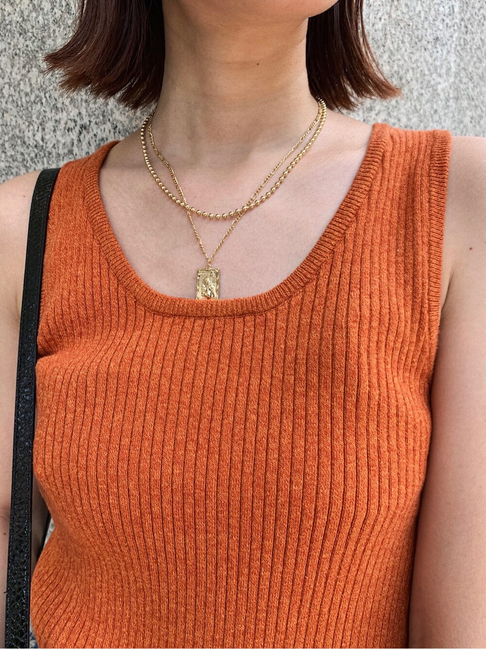 ブルー系のデニムパンツ、ブラック系のサンダル、オレンジ系のニット/セーターを着用したレディースの夏コーディネートの4枚目の写真