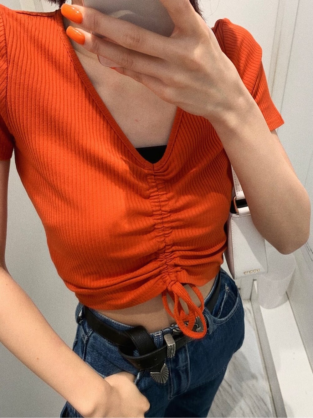 ブラック系のサンダル、ブルー系のデニムパンツ、ホワイト系のショルダーバッグを着用したレディースの春コーディネートの5枚目の写真