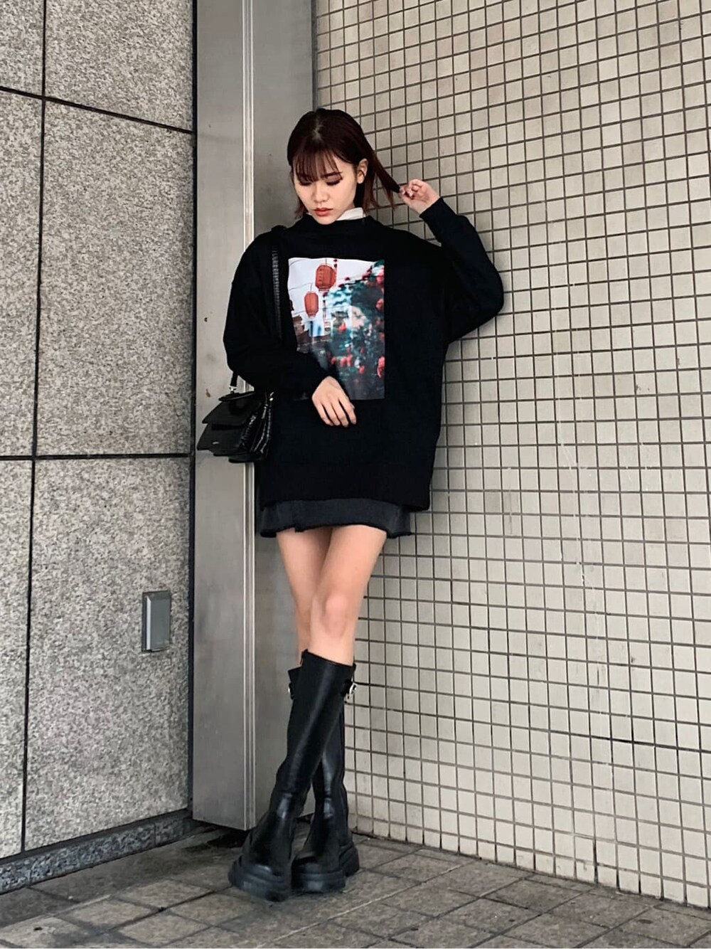 ブラック系のブーツ、ブラック系のデニムスカート、ブラック系のスウェットを着用したレディースの冬コーディネートの2枚目の写真