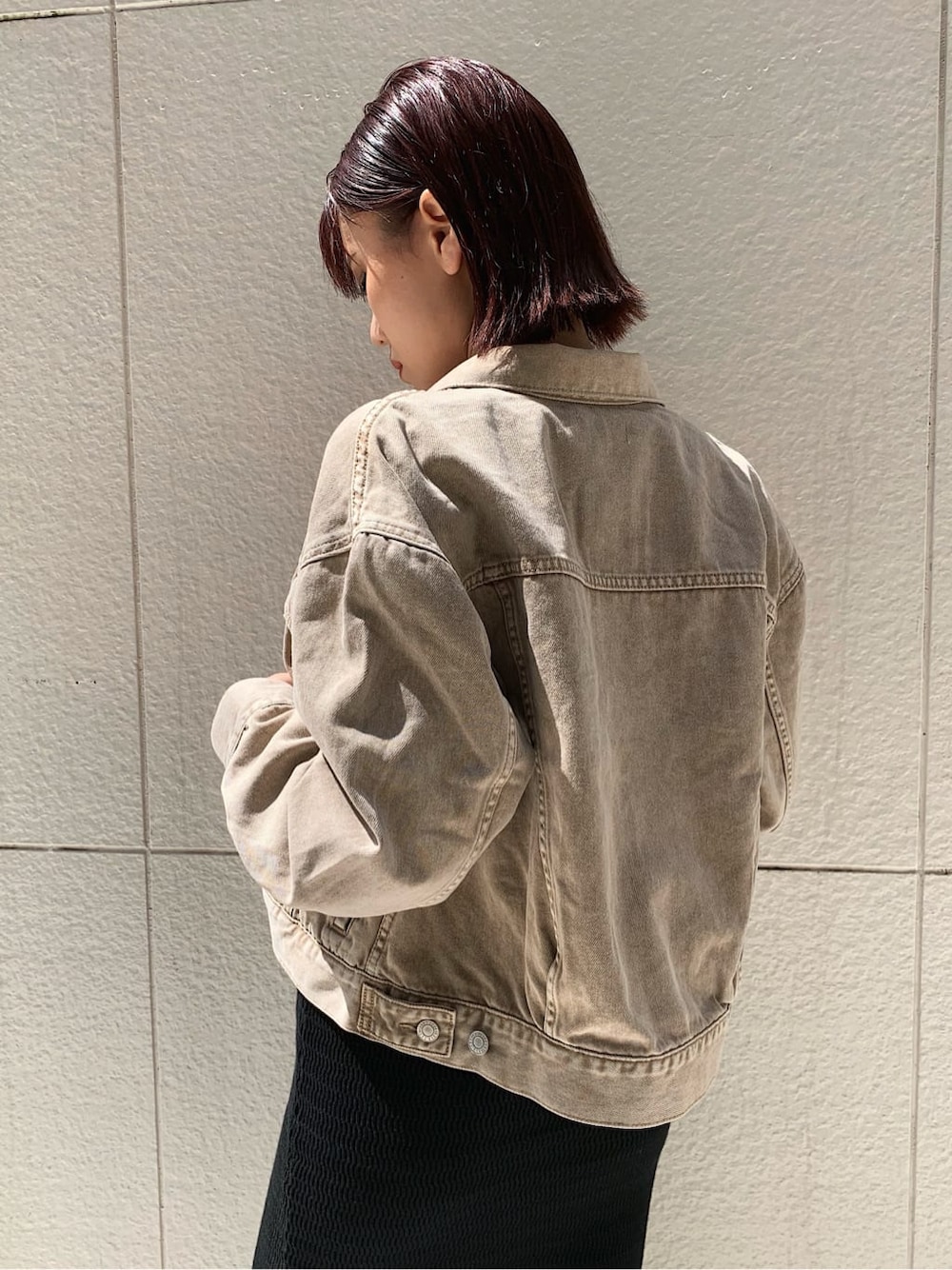 ベージュ系のデニムジャケット、ブラック系のブーツ、その他のショルダーバッグを着用したレディースの秋コーディネートの5枚目の写真