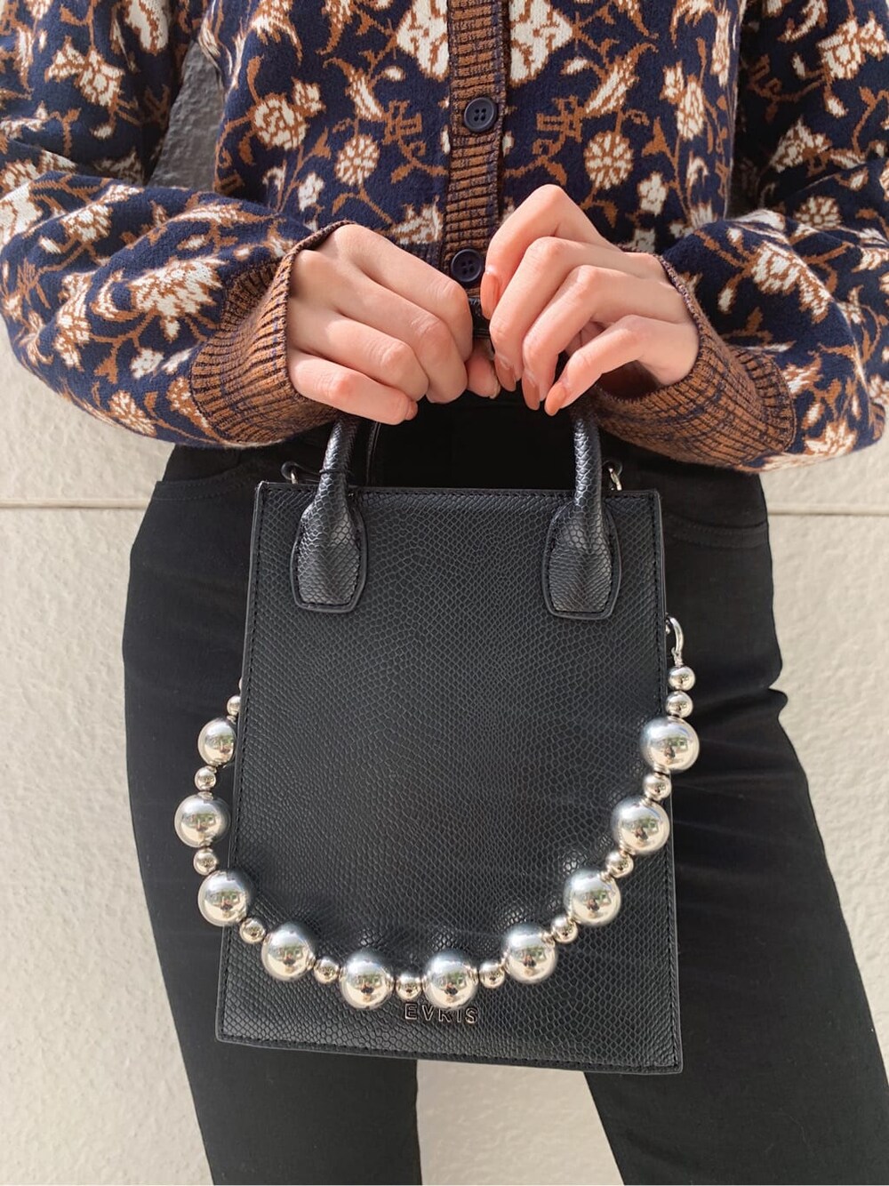 ブラック系のデニムパンツ、ブラック系のショルダーバッグ、ブラック系のブーツを着用したレディースの秋コーディネートの7枚目の写真