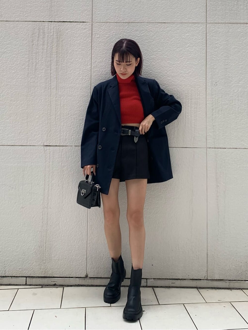 ブルー系のテーラードジャケット、ブラック系のハンドバッグ、ブラック系のブーツを着用したレディースの秋コーディネートの2枚目の写真