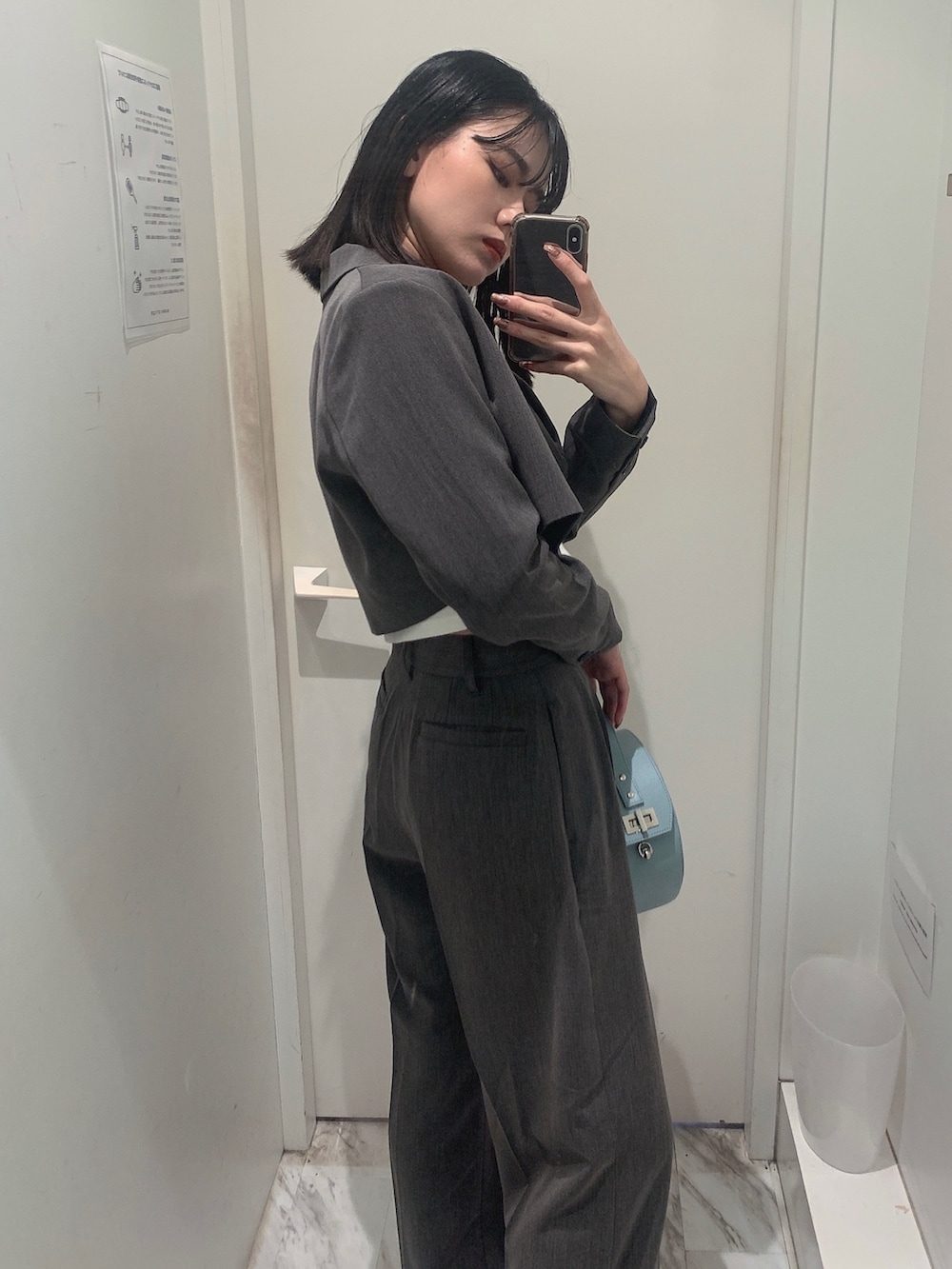 グレー系のその他パンツ、グレー系のテーラードジャケット、ブルー系のショルダーバッグを着用したレディースの春コーディネートの3枚目の写真