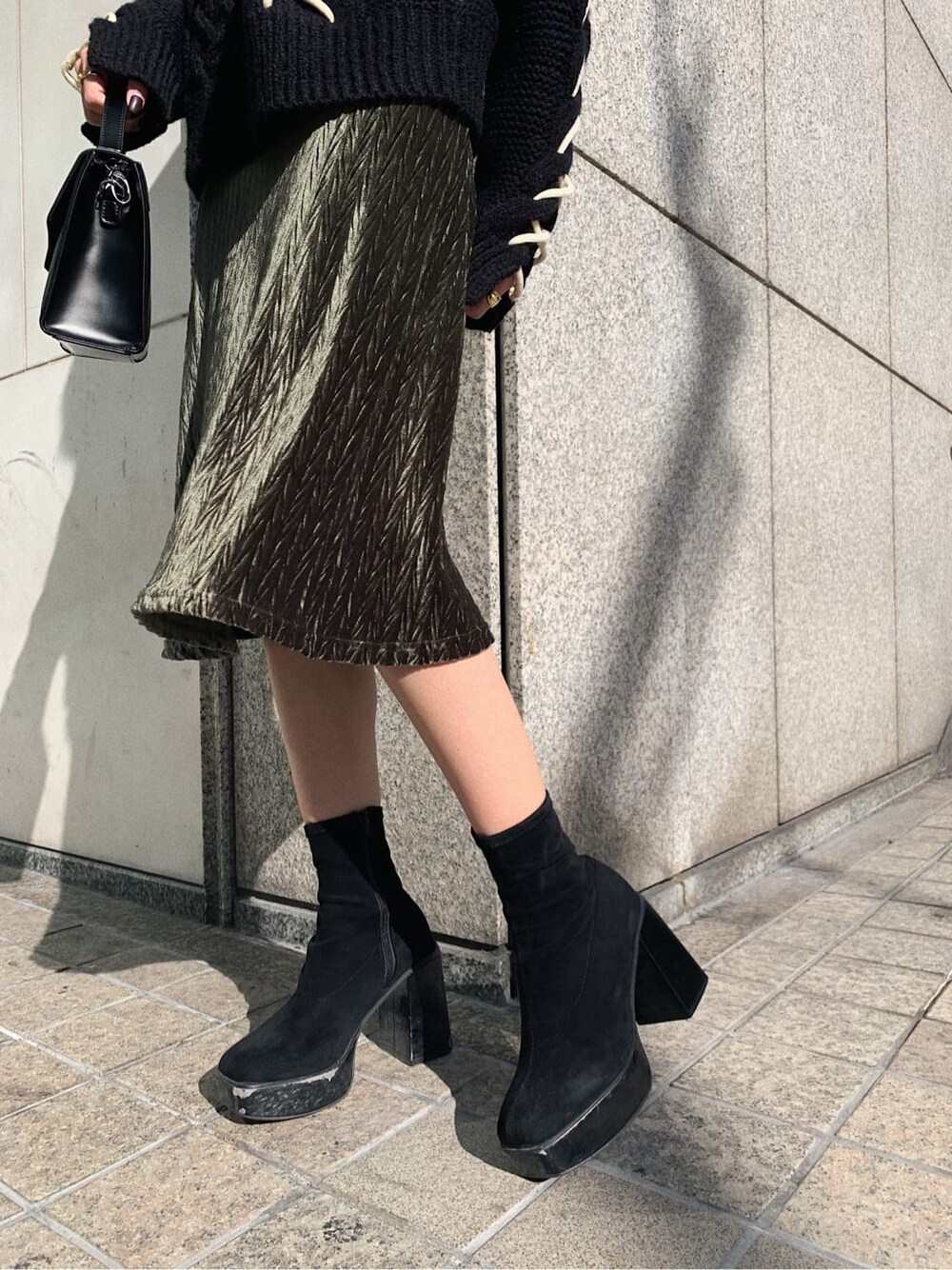 ブラック系のニット/セーター、ブラック系のショルダーバッグ、ベージュ系のワンピースを着用したレディースの冬コーディネートの6枚目の写真