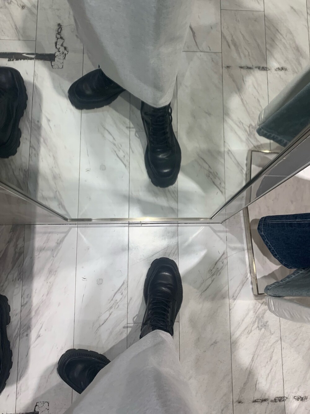 グレー系のワンピース、ブラック系のニット/セーター、ブラック系のブーツを着用したレディースの春コーディネートの6枚目の写真