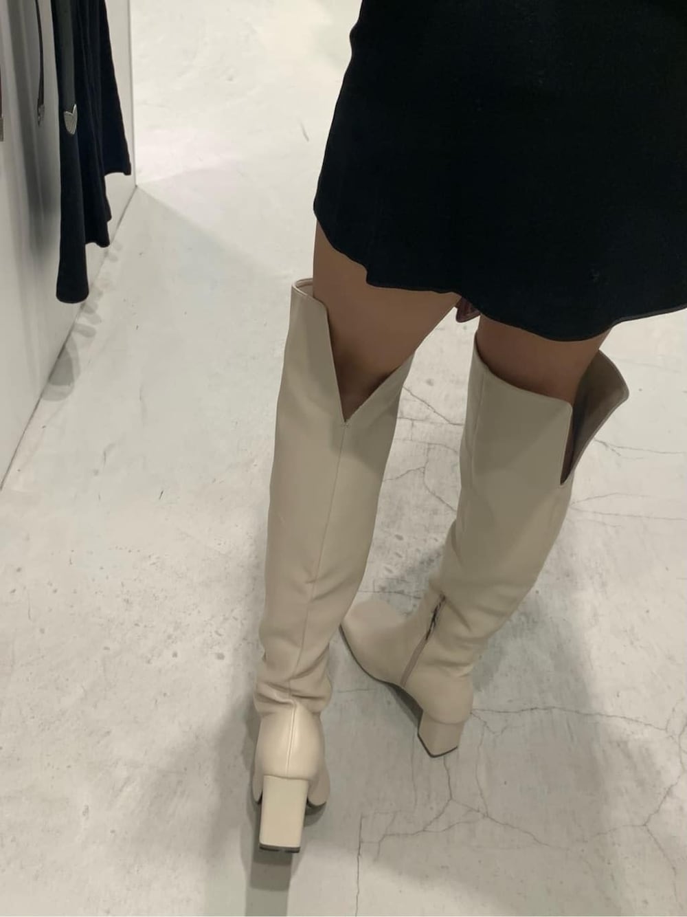 ブラック系のテーラードジャケット、ブラック系のスカート、ホワイト系のブーツを着用したレディースの秋コーディネートの10枚目の写真