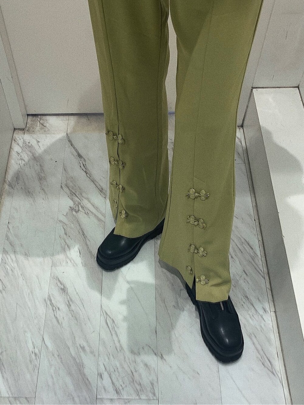 ブラック系のブーツ、ブラック系のブルゾン、グリーン系のその他パンツを着用したレディースの春コーディネートの6枚目の写真