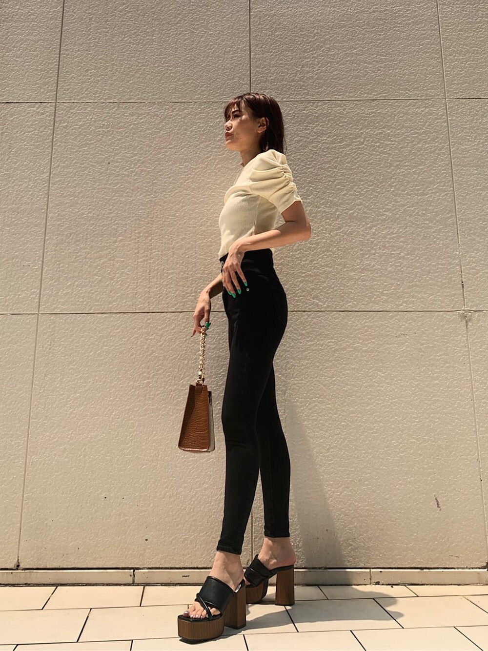 ブラック系のサンダル、ホワイト系のTシャツ/カットソーを着用したレディースの夏コーディネートの2枚目の写真