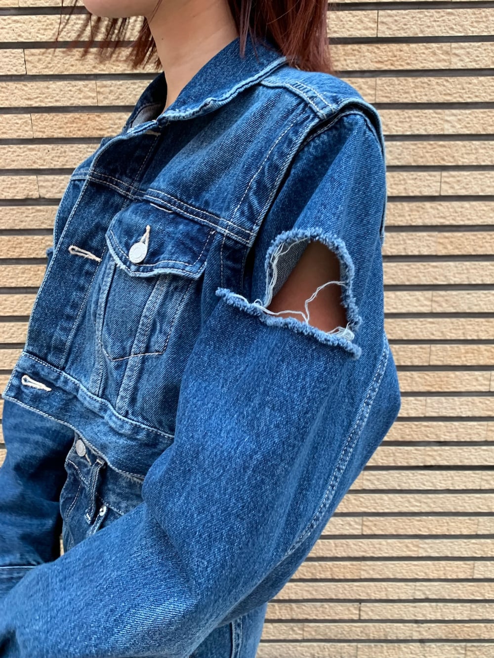 ブルー系のデニムジャケット、ブルー系のデニムスカート、レッド系のショルダーバッグを着用したレディースの秋コーディネートの6枚目の写真