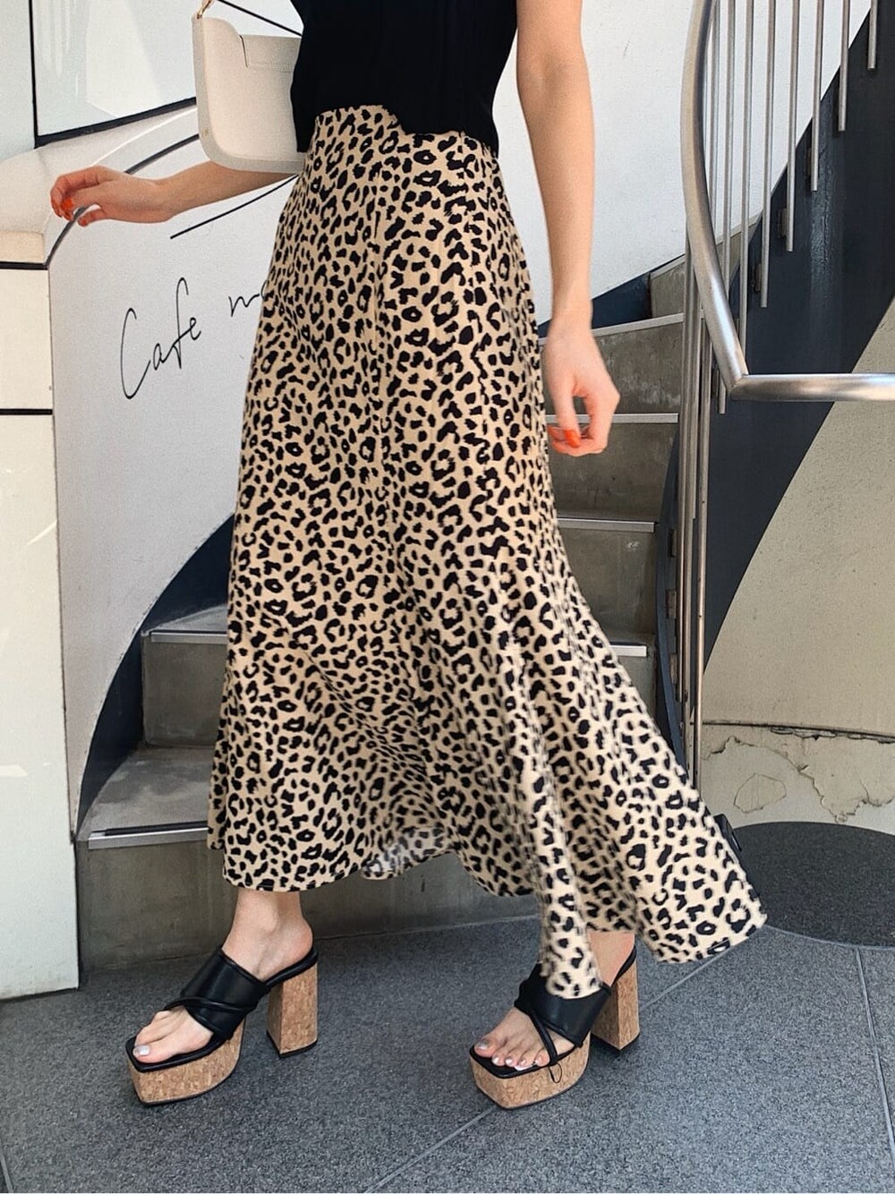 ブラック系のニット/セーター、ホワイト系のショルダーバッグ、その他のスカートを着用したレディースの春コーディネートの4枚目の写真