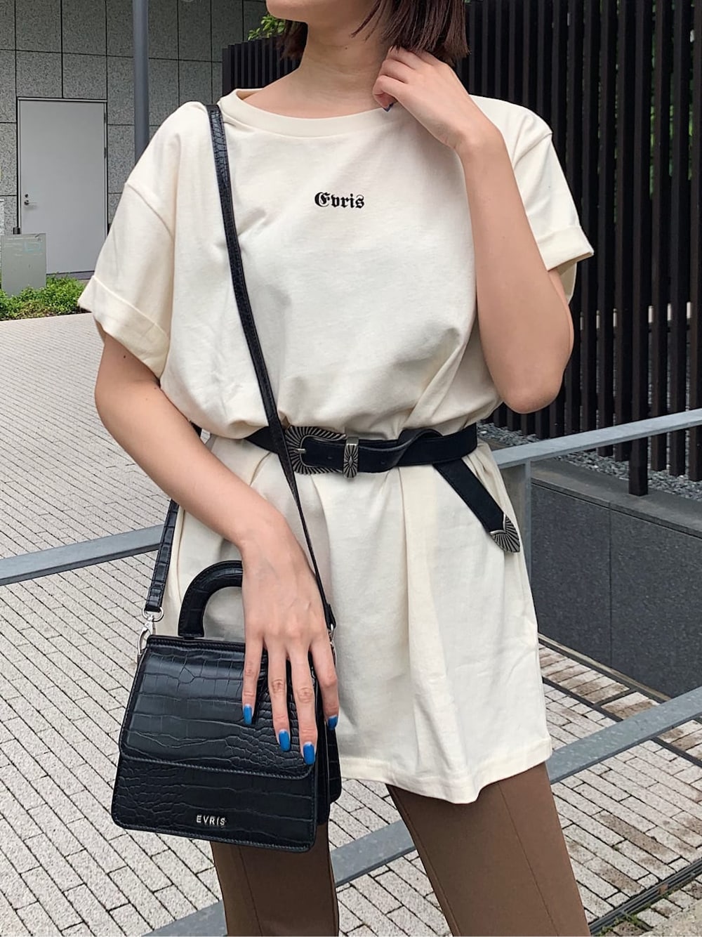 ブラック系のサンダル、ホワイト系のTシャツ/カットソー、ブラック系のベルトを着用したレディースの夏コーディネートの3枚目の写真