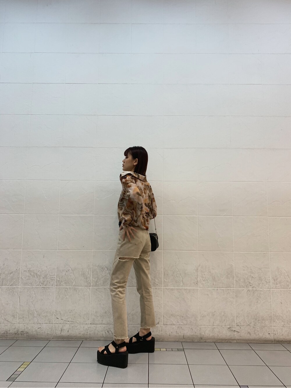 ブラウン系のキャミソール、ブラック系のサンダル、ベージュ系のデニムパンツを着用したレディースの春コーディネートの2枚目の写真